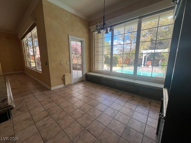 unfurnished dining area with ornamental molding, a wealth of natural light, light tile patterned floors, and a notable chandelier