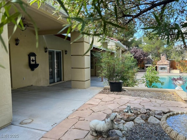 view of patio featuring ceiling fan and a fireplace