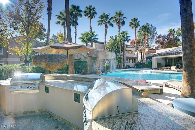 view of swimming pool featuring area for grilling and a patio area