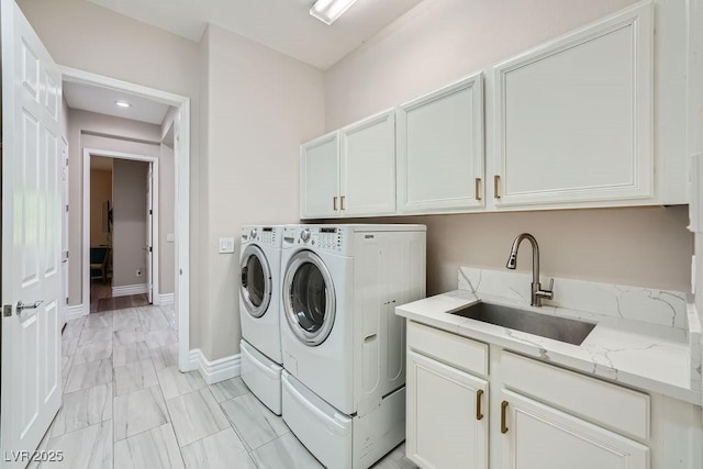 laundry area with washer and dryer, sink, and cabinets