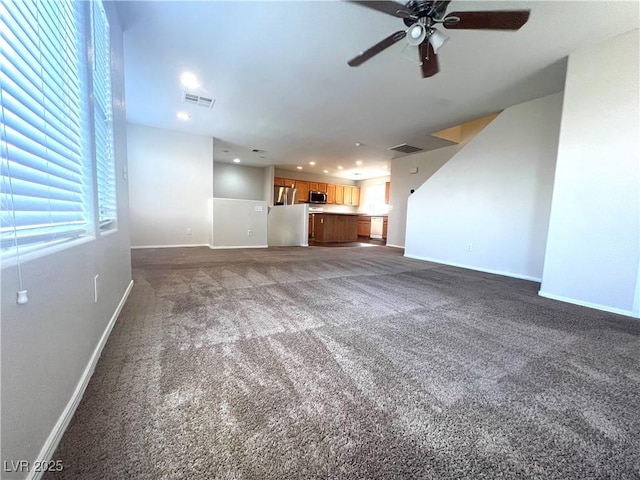 unfurnished living room featuring a ceiling fan, carpet flooring, visible vents, and baseboards