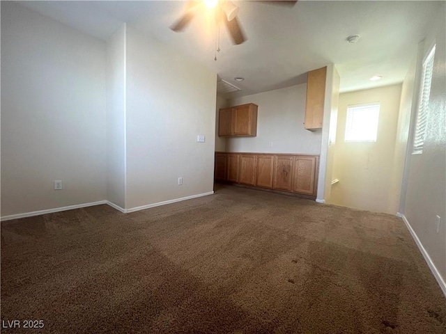 unfurnished living room featuring carpet floors, a ceiling fan, and baseboards