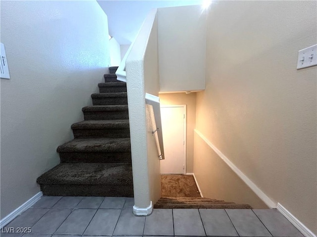 stairway with tile patterned flooring and baseboards