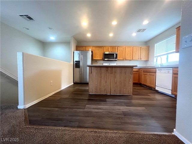 kitchen featuring recessed lighting, dark wood-style flooring, visible vents, appliances with stainless steel finishes, and a center island