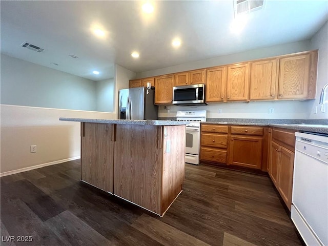 kitchen featuring appliances with stainless steel finishes, dark wood finished floors, visible vents, and a center island