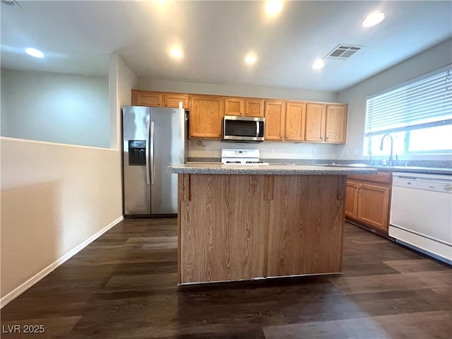 kitchen featuring recessed lighting, stainless steel appliances, dark wood-type flooring, a kitchen island, and visible vents