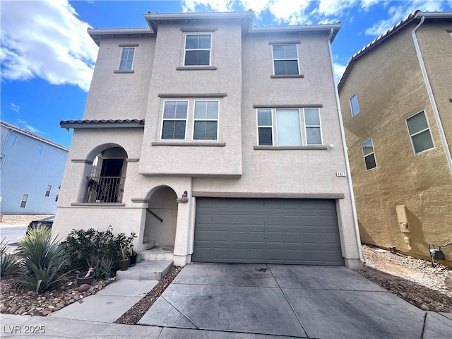 view of front of house featuring concrete driveway, an attached garage, and stucco siding