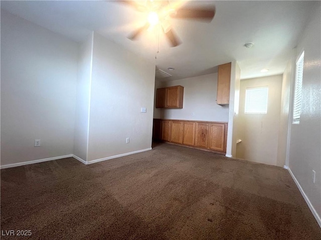 unfurnished living room with carpet, a ceiling fan, and baseboards