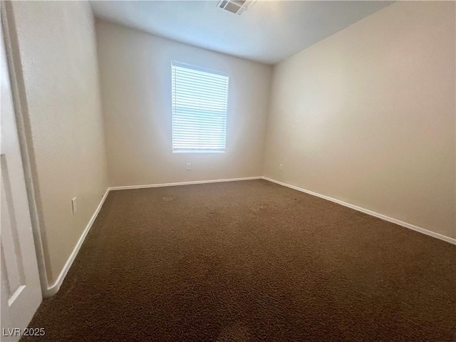 unfurnished room with baseboards, visible vents, and dark carpet