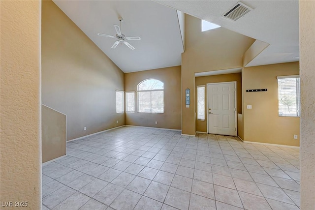 entrance foyer with light tile patterned flooring, ceiling fan, high vaulted ceiling, and a wealth of natural light