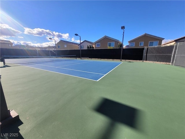 view of tennis court featuring fence