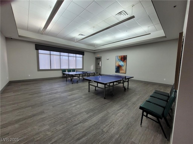 playroom featuring a raised ceiling, visible vents, baseboards, and wood finished floors