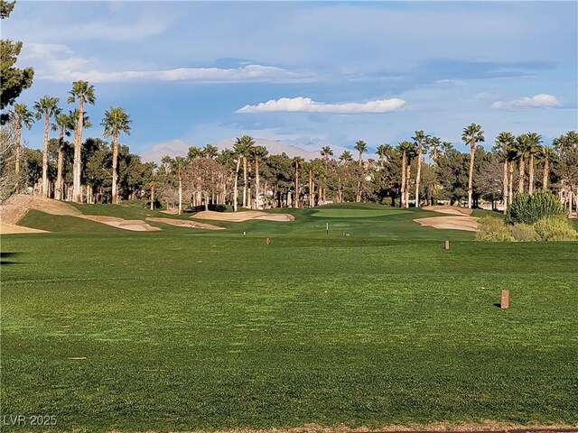 view of home's community featuring golf course view and a lawn