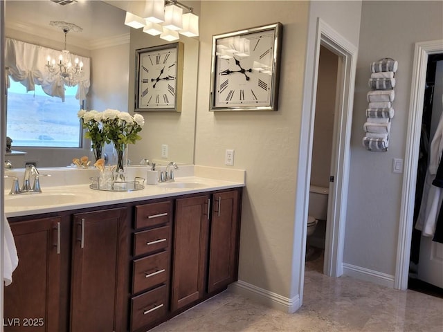 bathroom with ornamental molding, a sink, baseboards, and double vanity