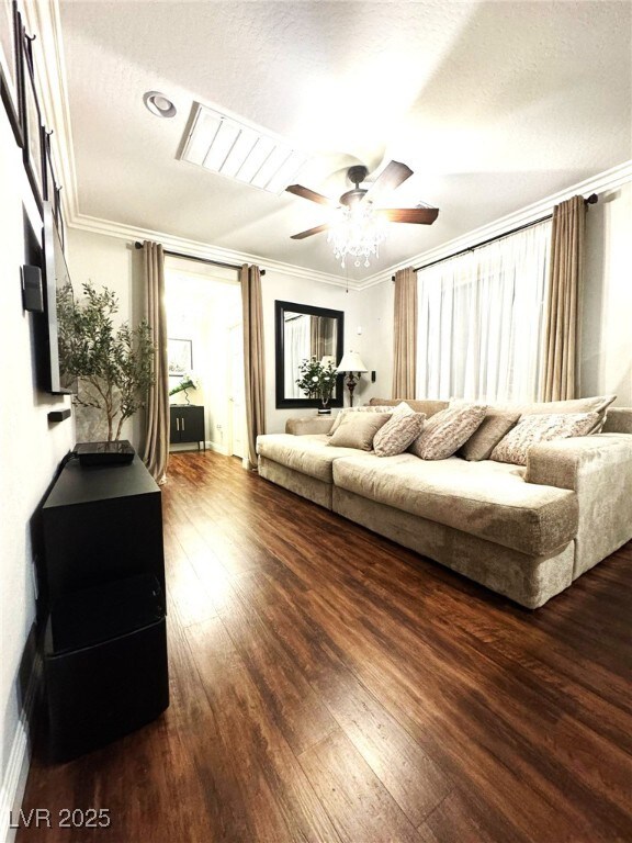 bedroom with ornamental molding, multiple windows, and wood finished floors