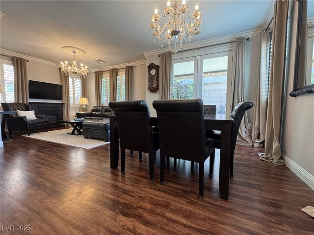 dining area featuring dark wood-style floors, a fireplace, an inviting chandelier, ornamental molding, and baseboards