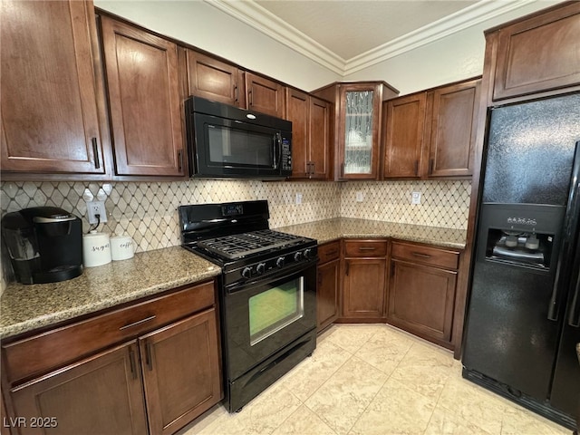 kitchen featuring crown molding, tasteful backsplash, glass insert cabinets, light stone countertops, and black appliances