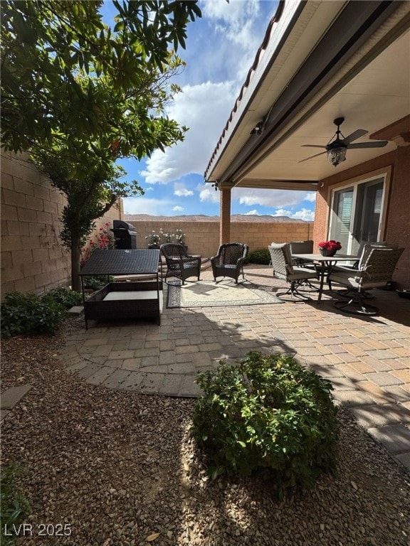 view of patio featuring ceiling fan, an outdoor hangout area, and a fenced backyard