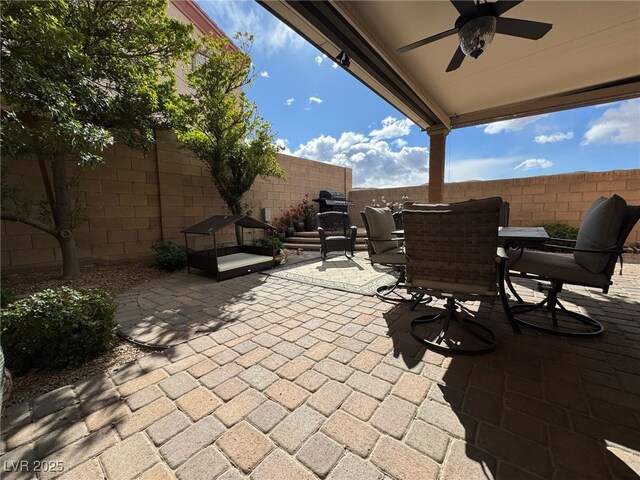 view of patio featuring outdoor dining space, a fenced backyard, and ceiling fan