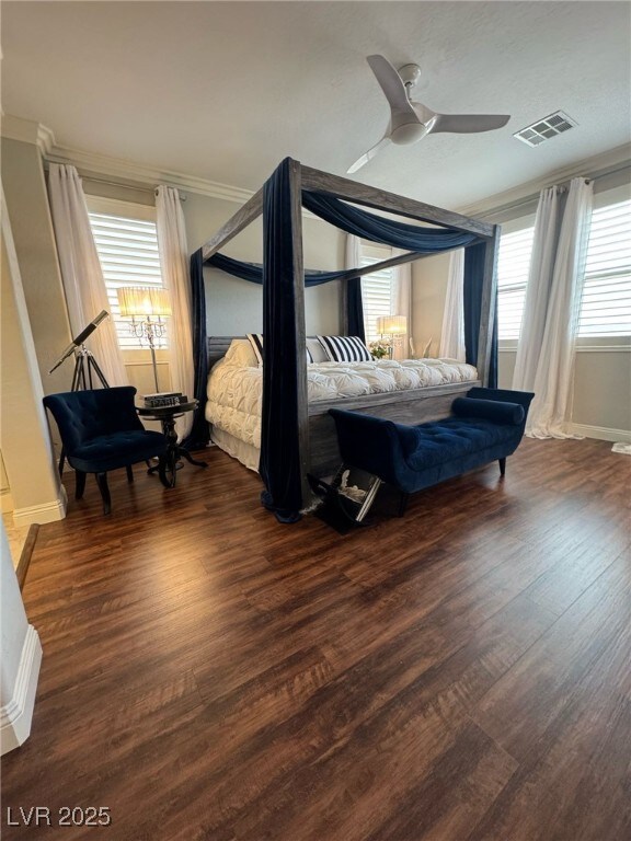 bedroom with baseboards, wood finished floors, visible vents, and a ceiling fan