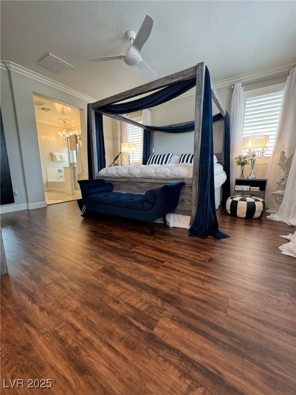 bedroom with ornamental molding, ceiling fan with notable chandelier, visible vents, and wood finished floors