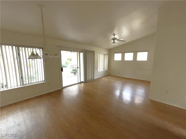 empty room with lofted ceiling, ceiling fan, baseboards, and wood finished floors