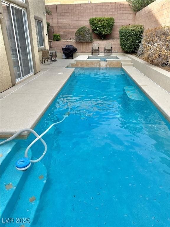 view of swimming pool with a patio and an in ground hot tub