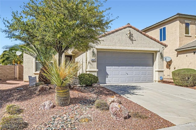 view of front facade with concrete driveway, a tiled roof, an attached garage, and stucco siding