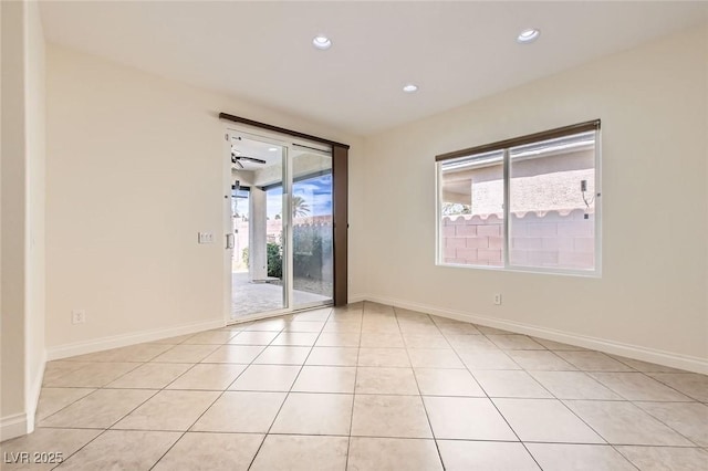 empty room featuring baseboards, light tile patterned floors, and recessed lighting