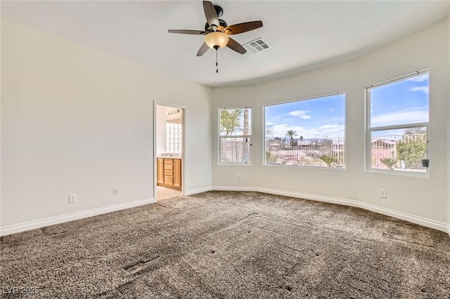 carpeted spare room with baseboards, visible vents, and a ceiling fan