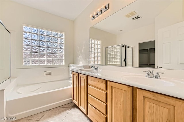 bathroom featuring tile patterned flooring, a sink, a bath, and a shower stall