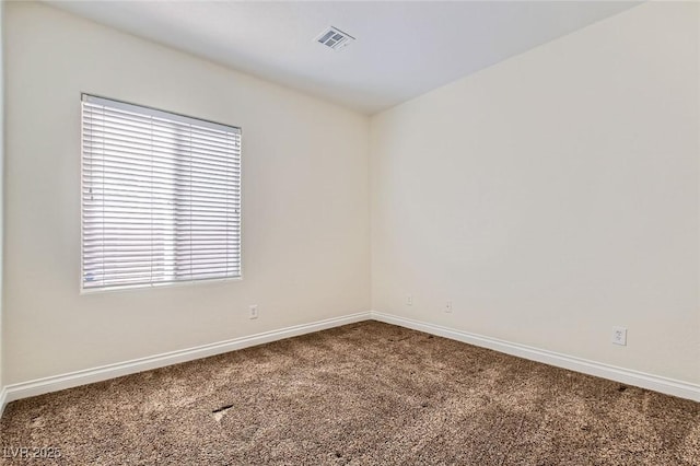 unfurnished room featuring carpet, visible vents, and baseboards