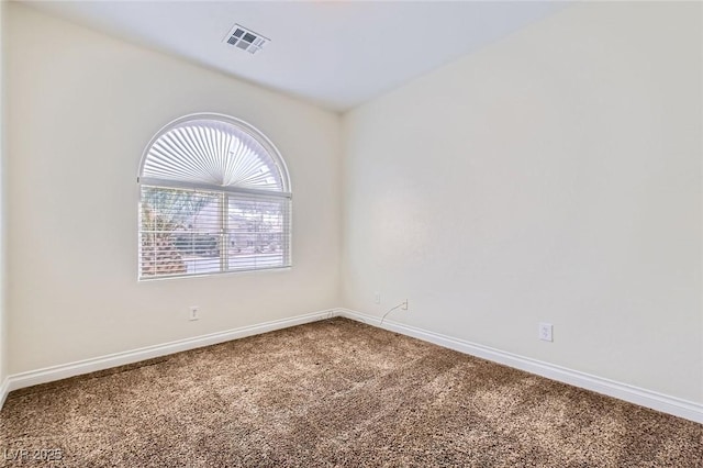 unfurnished room with carpet, visible vents, and baseboards