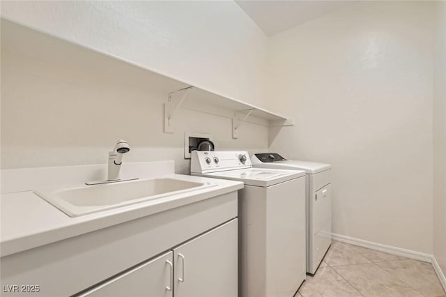 clothes washing area featuring cabinet space, light tile patterned floors, baseboards, washing machine and clothes dryer, and a sink