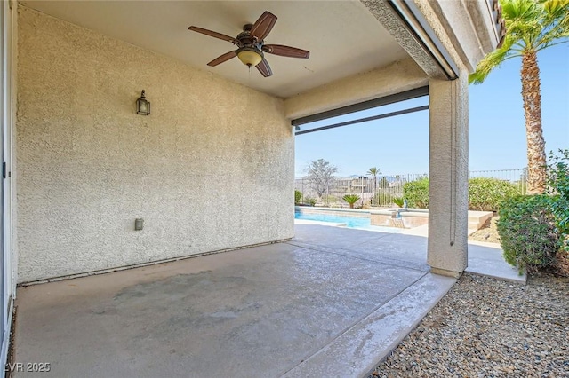 view of patio / terrace with ceiling fan, fence, and an outdoor pool