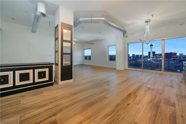 spare room featuring light hardwood / wood-style flooring and an inviting chandelier