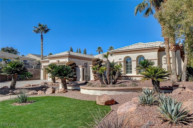 mediterranean / spanish-style house featuring a garage and a front yard