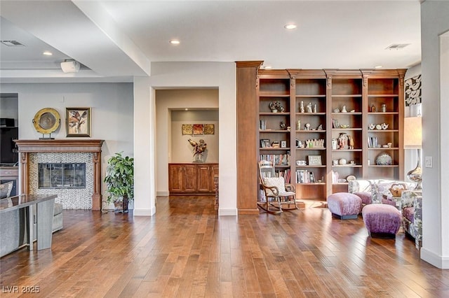 sitting room featuring a tiled fireplace and hardwood / wood-style floors