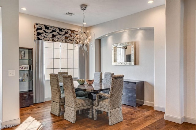 dining space featuring hardwood / wood-style flooring and a chandelier