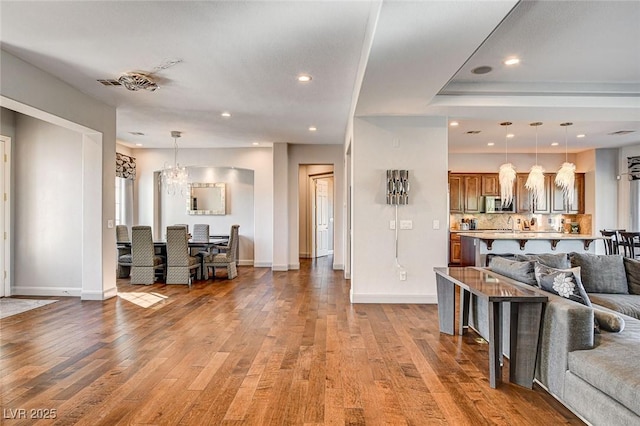 living room featuring an inviting chandelier and hardwood / wood-style flooring