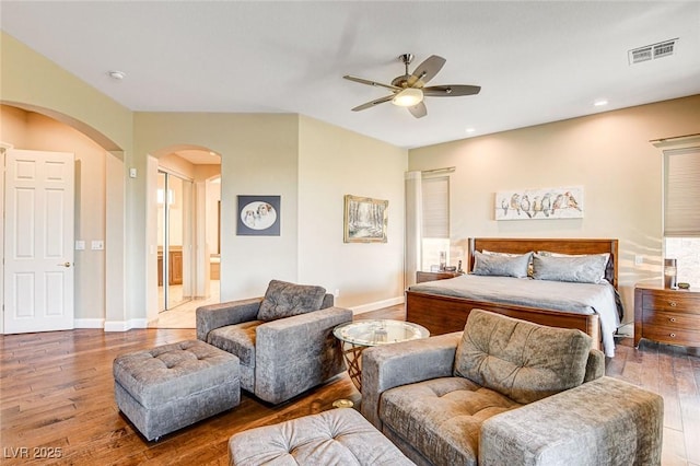 bedroom with ceiling fan, ensuite bathroom, and hardwood / wood-style floors