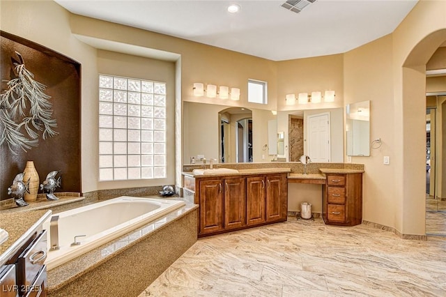 bathroom featuring vanity and tiled tub