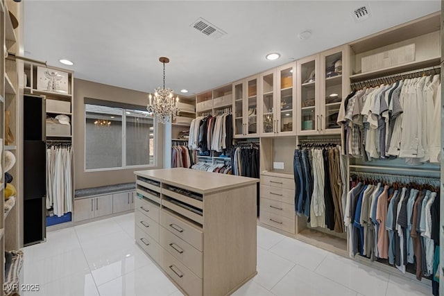 walk in closet with light tile patterned floors, visible vents, and a notable chandelier