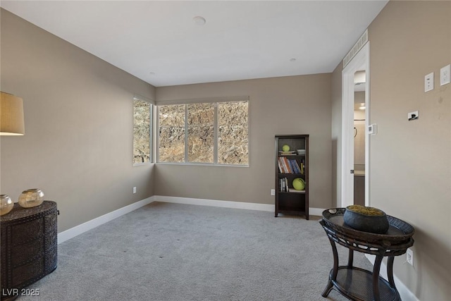 living area featuring carpet and baseboards