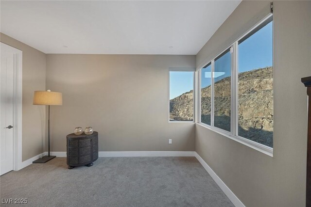 carpeted spare room featuring baseboards