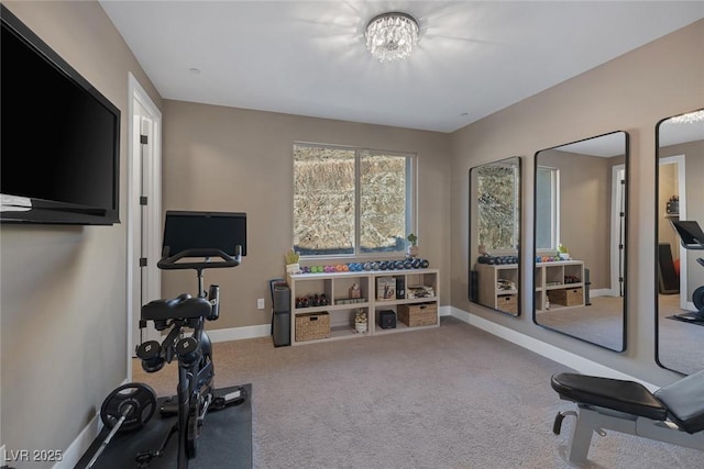 exercise area featuring baseboards and carpet flooring