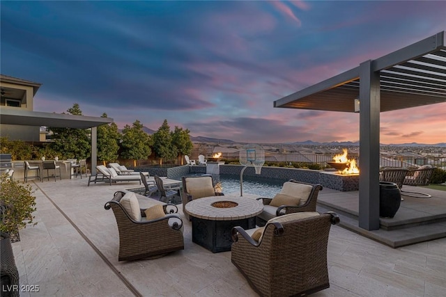 patio terrace at dusk featuring a fire pit and outdoor dry bar