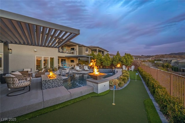 exterior space with fence, a fire pit, and a balcony