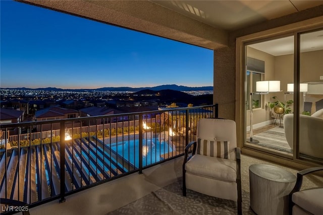 balcony at dusk featuring a mountain view