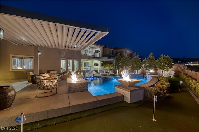 pool at night with a fenced in pool, an outdoor living space with a fire pit, and a patio area